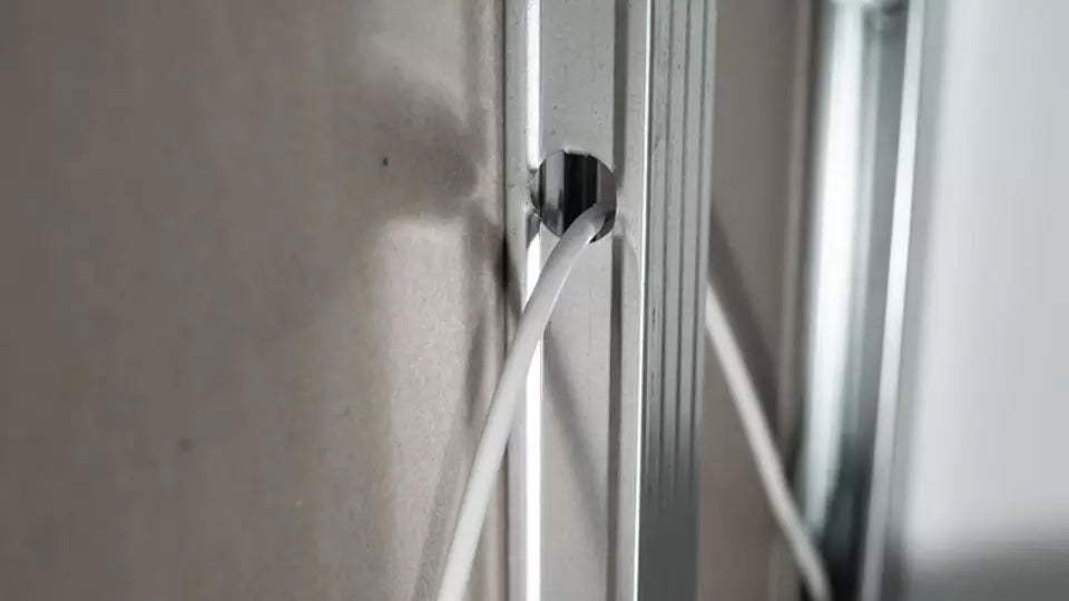 Elektrakabel door de opening in een metalen staander van een gipsplaatwand